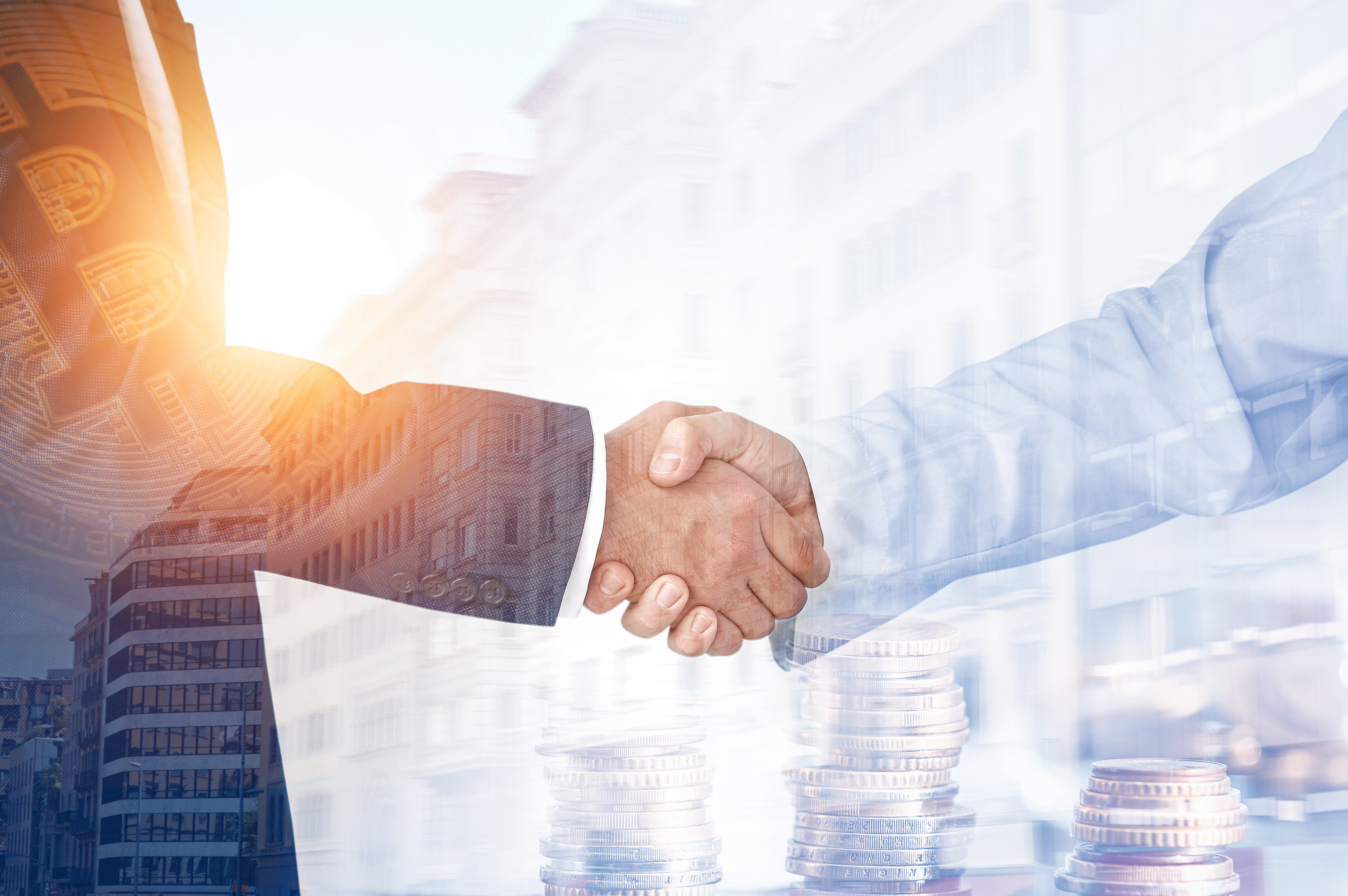 Multiple exposure of business partners shaking hands, coins and modern city